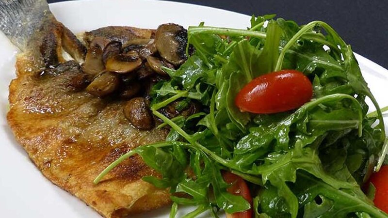 Bronzino filet pan seared topped with aurugla salad & sauteed mushrooms