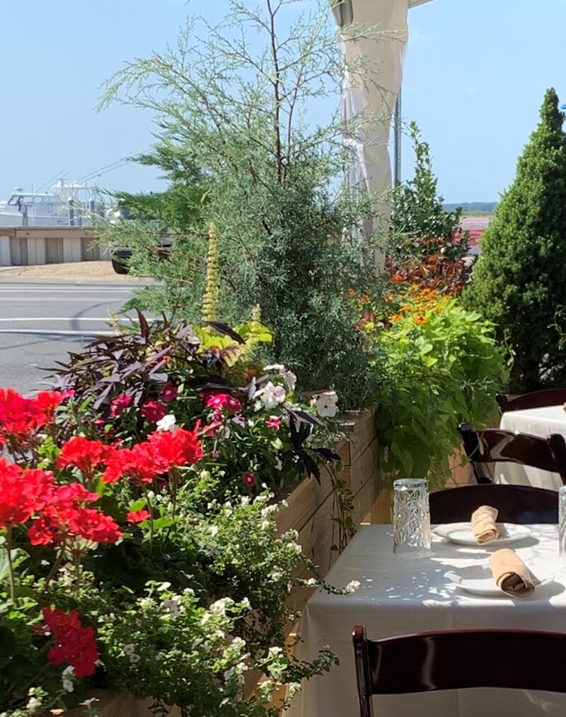 Outside dining area with view of bay and boat in background