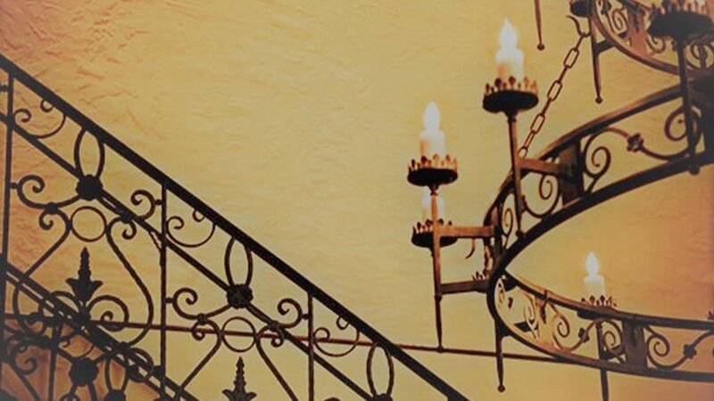View of cast iron stair case and chandelier