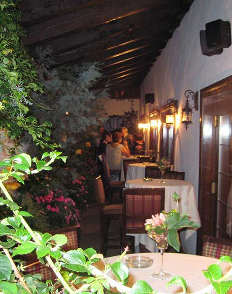 Outside courtyard featuring diners in a floral setting