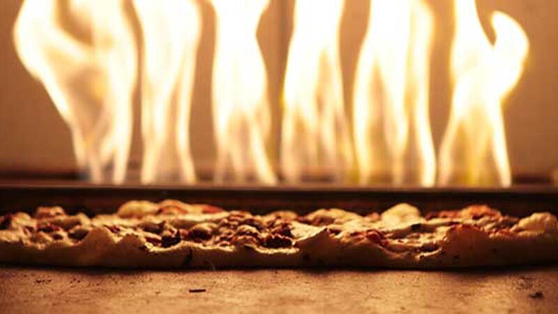 Flatbread being cooked in brick oven